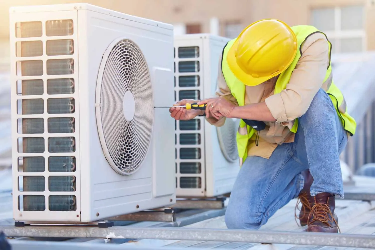 Technician servicing outdoor air conditioning units